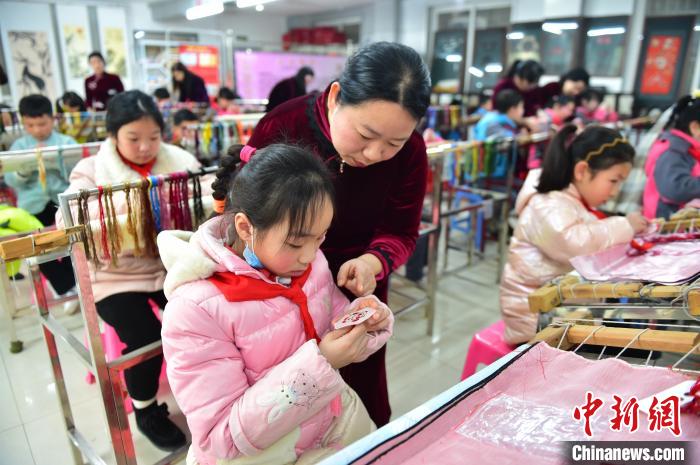 江西省級非遺豫章繡傳承人手把手指導小學生繡制2022年北京冬奧會吉祥物“冰墩墩”形象?！∮髟屏?攝