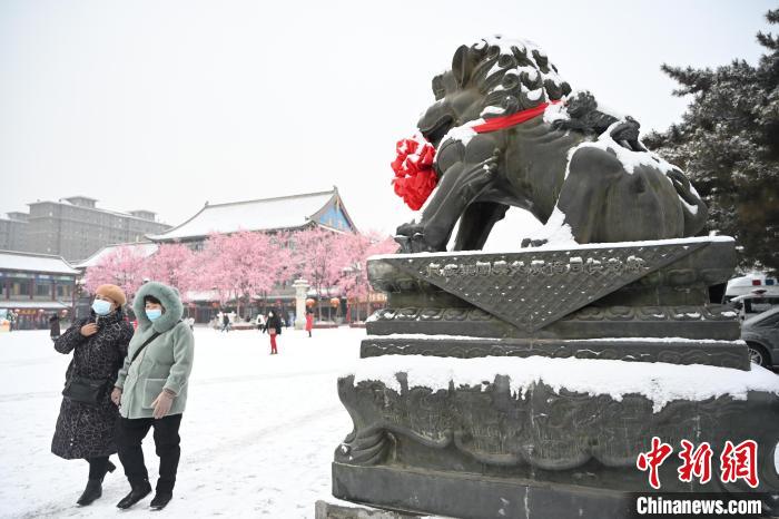 2月13日，民眾在呼和浩特市大召?gòu)V場(chǎng)雪中漫步?！⑽娜A 攝