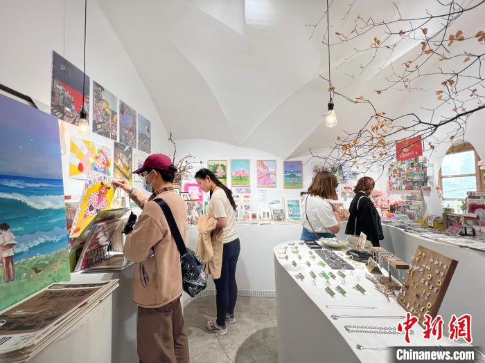圖為藝術(shù)品商店內(nèi)，顧客挑選插畫作品。　鐘旖 攝