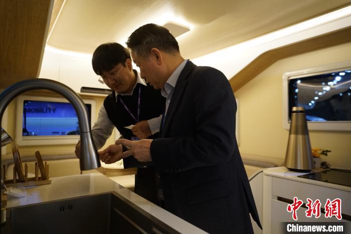 圖為參展商向觀眾介紹房車內(nèi)部設(shè)計?！⑿?攝