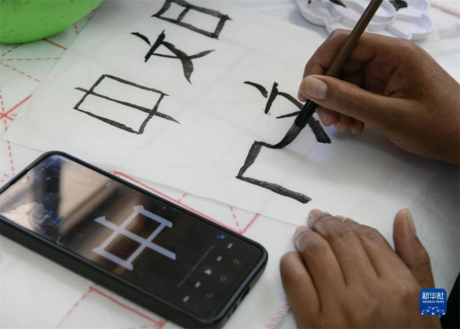 4月18日，肯尼亞學(xué)生在內(nèi)羅畢大學(xué)孔子學(xué)院舉辦的活動(dòng)上寫毛筆字?？夏醽唭?nèi)羅畢大學(xué)孔子學(xué)院18日舉辦“中文，增進(jìn)文明對話”主題活動(dòng)，慶祝即將到來的第14個(gè)聯(lián)合國中文日?？夏醽唽W(xué)生參與互動(dòng)，進(jìn)行書法、剪紙、唱中文歌等活動(dòng)。新華社記者 韓旭 攝