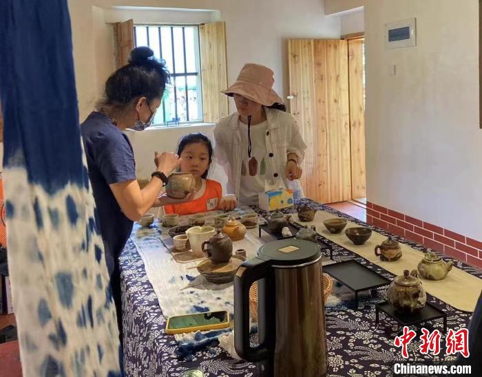 圖為：游客正在咨詢臺灣柴燒作品。　葉秋云 攝