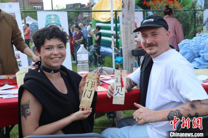 當(dāng)?shù)孛癖娫跐h字體驗(yàn)工作坊展示自己手寫的中文名書簽。　魯汶孔子學(xué)院供圖