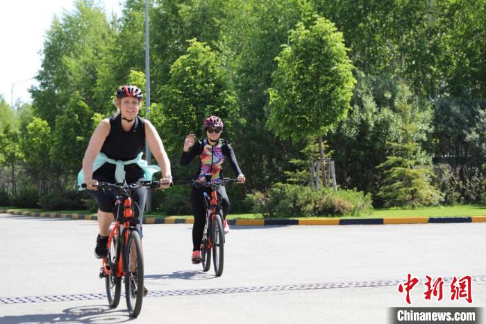 亞信副秘書長遲方(右一)與聯(lián)合國駐哈協(xié)調(diào)員在騎行活動(dòng)中?！喰琶貢幑﹫D