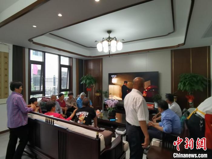 親友們集中在費(fèi)俊龍家中觀看返程的視頻?！＄娚?攝