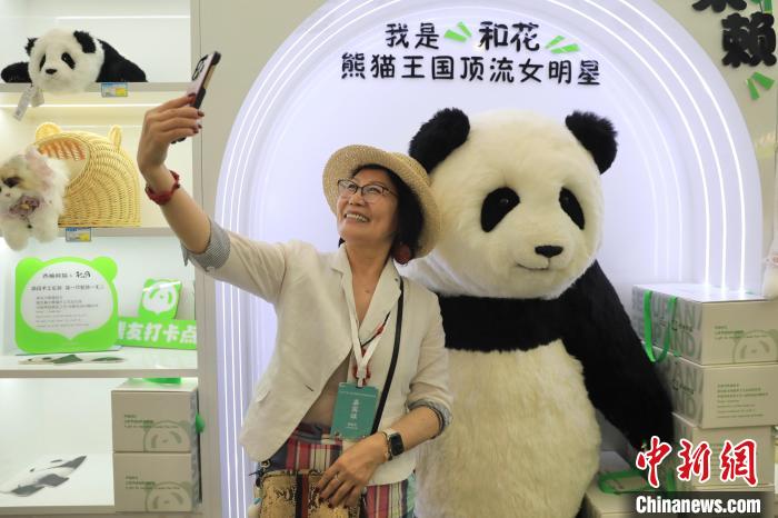 美國(guó)華視總裁楊蓮花與大熊貓文創(chuàng)產(chǎn)品合影?！⊥趵?攝