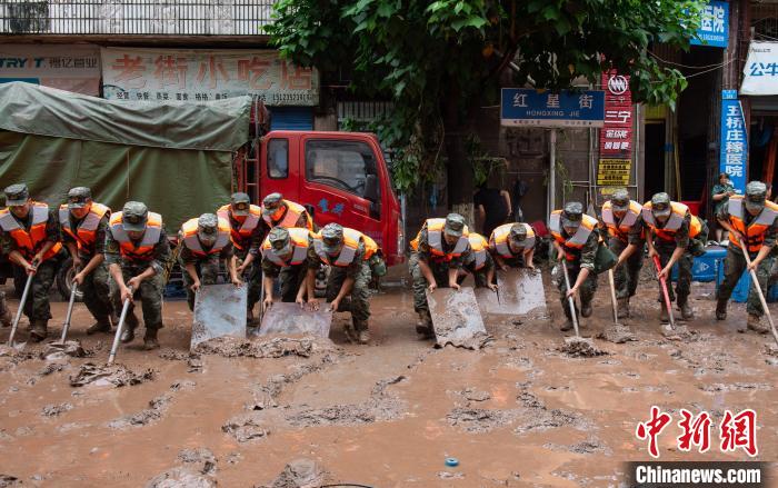 7月4日，萬州區(qū)五橋街道，武警官兵清理街道上的淤泥?！∪矫宪?攝
