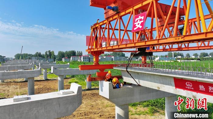 長25米重80噸的箱梁平穩(wěn)、精準地落在S314分離式立交橋25號和26號墩上?！⒂癫?攝