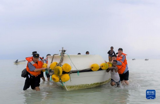 7月21日，中國海軍“和平方舟”號醫(yī)院船醫(yī)護人員涉水登島，前往基里巴斯一診療點。新華社記者 黎云 攝