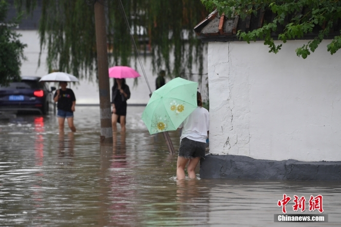 7月31日，市民行走在雨中的北京房山區(qū)瓦窯頭村。北京市氣象臺當日10時發(fā)布分區(qū)域暴雨紅色預警信號。北京市水文總站發(fā)布洪水紅色預警，預計當日12時至14時，房山區(qū)大石河流域將出現(xiàn)紅色預警標準洪水。<a target='_blank' href='/'><p  align=