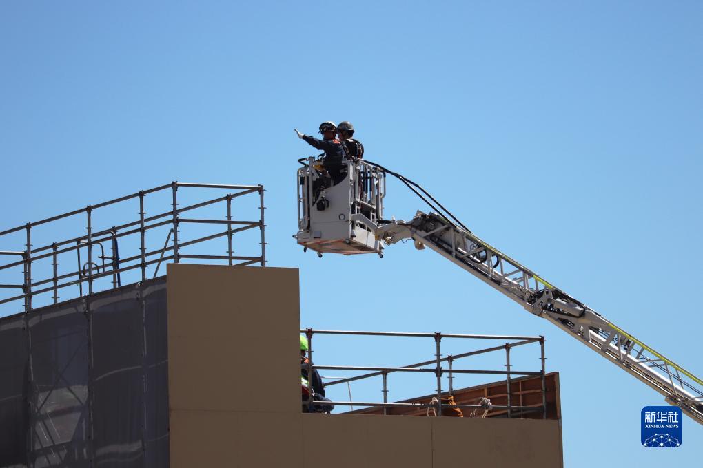 9月1日，在日本神奈川縣相模原市，消防員演練用消防云梯車(chē)救下被困高樓的民眾。9月1日是日本防災(zāi)日。當(dāng)天，日本中央政府及多個(gè)都縣市舉行了防災(zāi)演練，以提高大規(guī)模災(zāi)害發(fā)生時(shí)防災(zāi)機(jī)構(gòu)和市民迅速應(yīng)對(duì)的能力。新華社記者 楊光 攝