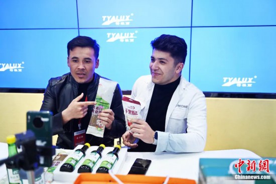 2023年3月，甘肅省慶陽市環(huán)縣電商創(chuàng)業(yè)孵化基地內(nèi)，來自蘭州文理學(xué)院的塔吉克斯坦留學(xué)生正在協(xié)助主播直播帶貨當(dāng)?shù)剞r(nóng)特產(chǎn)品。李亞龍 攝