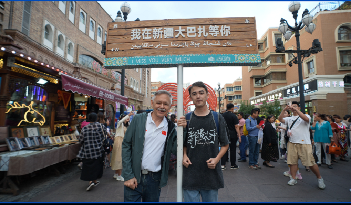 潘維廉和維吾爾族青年伊木蘭“打卡”大巴扎。主辦方供圖