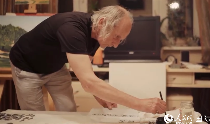 伊戈爾·布爾東諾夫在畫作上題詞。人民網(wǎng)記者 馬天翼攝