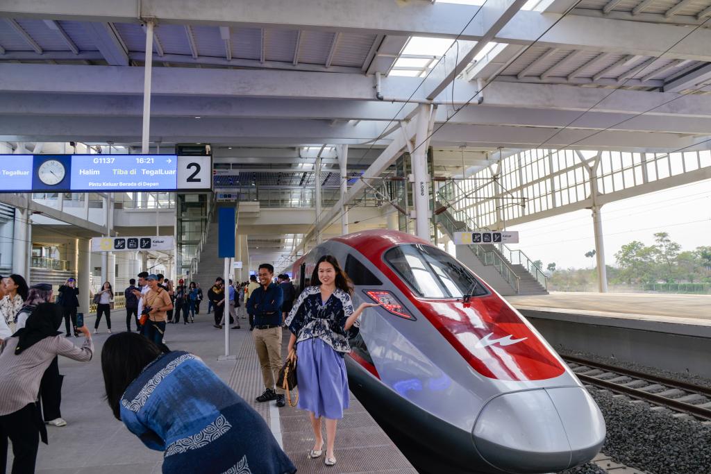 10月17日，在印度尼西亞萬隆德卡魯爾站，乘客在站臺上和雅萬高鐵高速動車組列車合影。