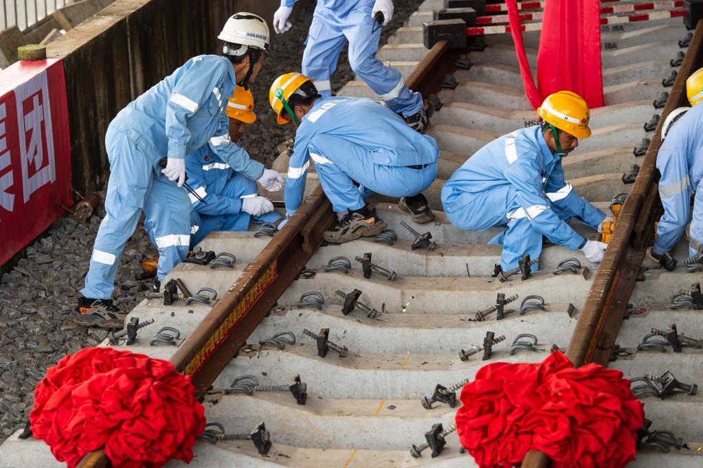 3月31日，在印度尼西亞雅加達雅萬高鐵哈利姆車站，工人鋪設(shè)雅萬高鐵全線最后一根鋼軌。