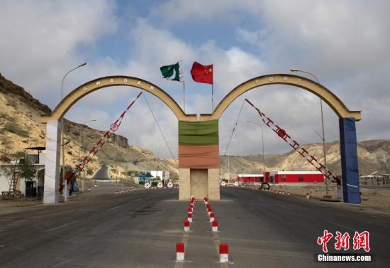 5月5日，瓜達(dá)爾港出入口的拱門。瓜達(dá)爾港是阿拉伯海沿岸的一座天然不凍良港，也是中巴經(jīng)濟(jì)走廊的南端起點(diǎn)。中國(guó)公司自2013年開始取得瓜達(dá)爾港的運(yùn)營(yíng)權(quán)，目前各項(xiàng)工作逐步展開。盡管自然條件差、物資匱乏，但瓜達(dá)爾卻有著重要的地理位置。瓜達(dá)爾是巴基斯坦通往波斯灣和阿拉伯海的大門，距離霍爾木茲海峽僅400公里。作為一帶一路有益補(bǔ)充的中巴經(jīng)濟(jì)走廊經(jīng)濟(jì)構(gòu)架的確立，使位于巴基斯坦最南端的瓜達(dá)爾港成為中巴經(jīng)濟(jì)走廊的一個(gè)重要出?？凇?lt;a target='_blank' href='/'><p  align=