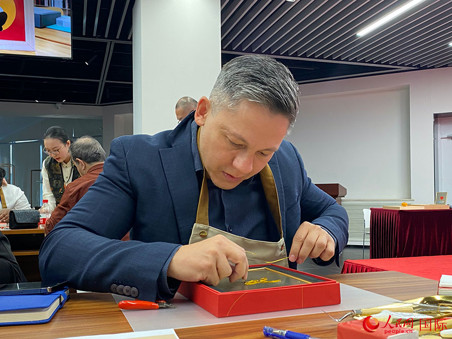 2023“一帶一路”媒體合作論壇聯(lián)合采訪團(tuán)團(tuán)員，親身體驗(yàn)景泰藍(lán)工藝。人民網(wǎng)記者 于洋攝