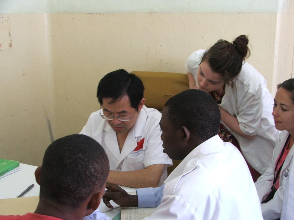 2011年7月22日，在坦桑尼亞桑給巴爾納茲莫加醫(yī)院外科門診，中國第24批援桑給巴爾醫(yī)療隊隊長盧建林為當?shù)鼗颊咴\治并帶教實習生。新華社發(fā)（國家衛(wèi)生健康委供圖）