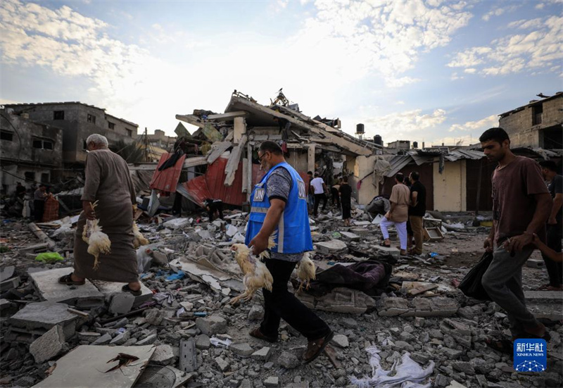 10月27日，在加沙地帶南部城市汗尤尼斯，人們經(jīng)過(guò)以軍襲擊后的房屋廢墟。