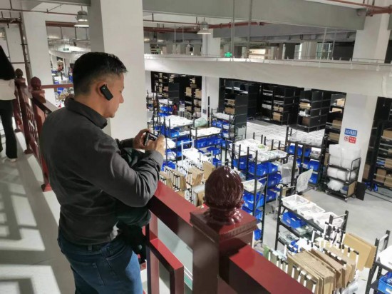 2023“一帶一路”媒體合作論壇聯(lián)合采訪團(tuán)團(tuán)員在仁和醫(yī)藥物流園拍攝記錄轉(zhuǎn)運(yùn)流程。（本報(bào)記者 黃超攝）