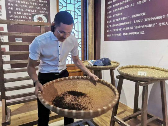 2023“一帶一路”媒體合作論壇聯(lián)合采訪團(tuán)團(tuán)員在非遺文化展示館體驗(yàn)中藥炮制技藝。（本報(bào)記者 黃超攝）