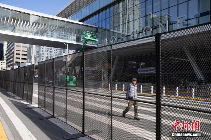 當(dāng)?shù)貢r(shí)間11月10日，一名行人從美國(guó)舊金山莫斯康中心周圍的金屬圍欄旁經(jīng)過(guò)。隨著亞太經(jīng)合組織(APEC)第三十次領(lǐng)導(dǎo)人非正式會(huì)議臨近，作為會(huì)議場(chǎng)地的莫斯康中心附近出現(xiàn)金屬圍欄，執(zhí)勤警察也大幅增加。<a target='_blank' href='/'><p  align=