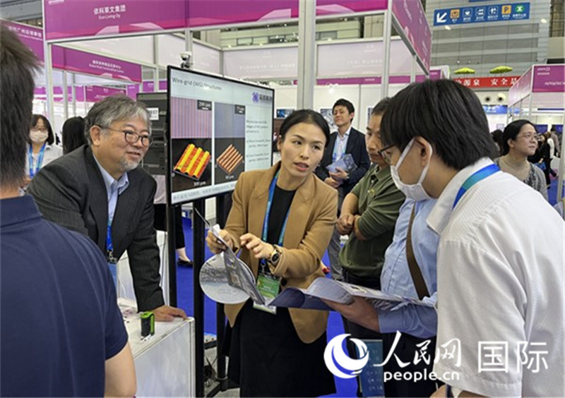 工作人員向參觀者介紹超級(jí)噴墨技術(shù)。（人民網(wǎng)記者 陳思攝）