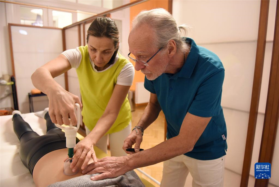 12月12日，在奧地利維也納，科格勒醫(yī)生（右）和助手在為病人進(jìn)行拔罐治療。新華社記者 賀燦鈴 攝