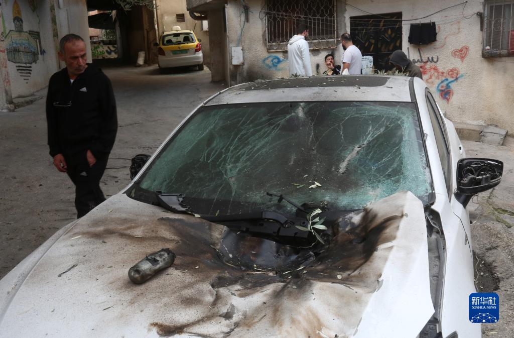 12月17日，在約旦河西岸城市圖勒凱爾姆附近的一處難民營(yíng)，人們查看在沖突中損毀的車輛。新華社發(fā)（尼達(dá)爾·艾仕塔耶?dāng)z）