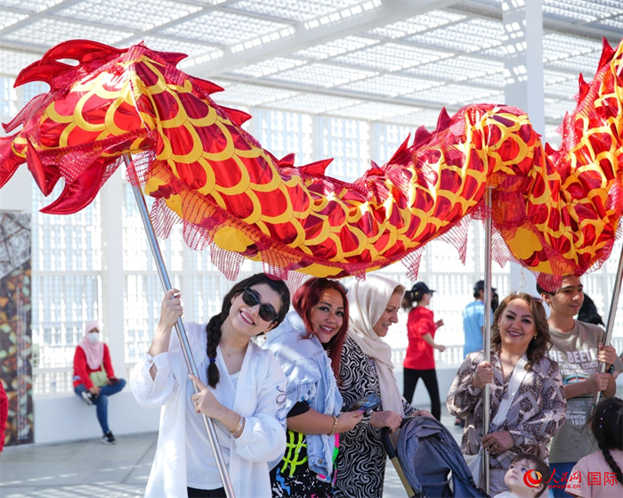 游客體驗(yàn)舞龍。 人民網(wǎng) 塔里克·易卜拉欣攝