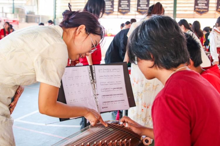 志愿者教師指導(dǎo)學(xué)生彈奏古箏?；顒?dòng)主辦方供圖