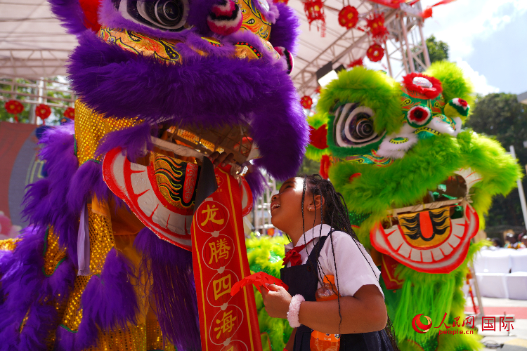 小朋友與舞獅表演者互動(dòng)。人民網(wǎng)記者 黃煒鑫攝