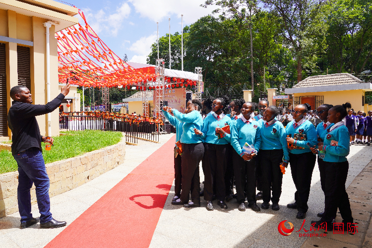 一名老師在給學(xué)生拍照留念。人民網(wǎng)記者 黃煒鑫攝