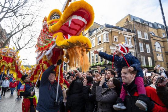 2月11日，人們在英國倫敦的新春巡游活動中觀看舞龍表演。新華社發(fā)（史蒂芬·程攝）