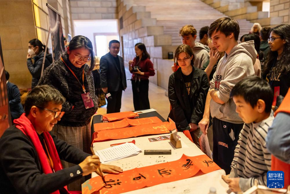 2月11日，書法家在美國費(fèi)城藝術(shù)博物館舉行的龍年迎新春活動上為參觀者書寫對聯(lián)。新華社發(fā)（周煥新攝）