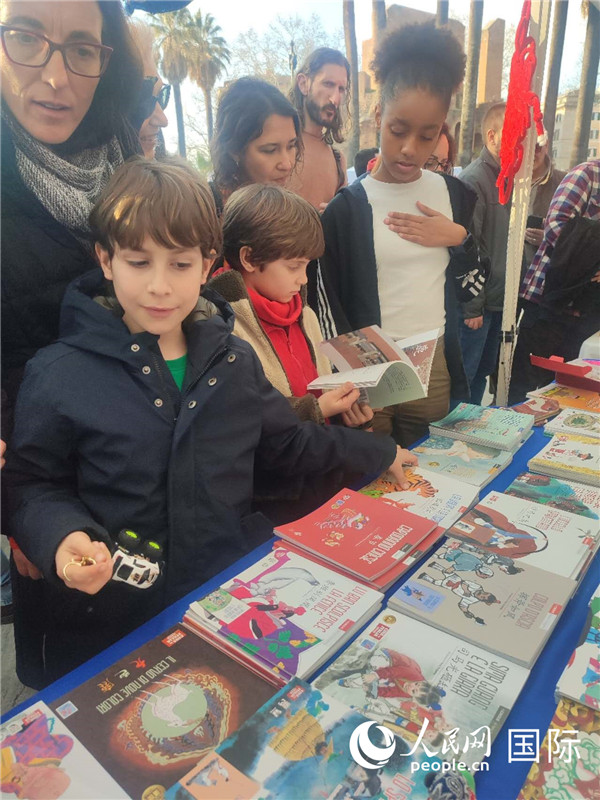 印刷精美的中國傳統(tǒng)文化叢書吸引了小游客的注意。人民網(wǎng)記者鄭彬攝