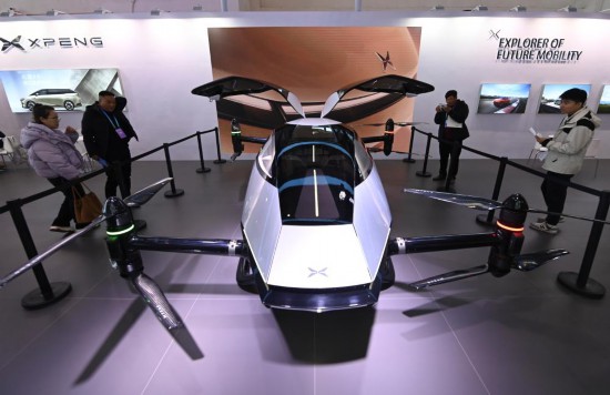 2023年12月1日，在鏈博會(huì)智能汽車鏈展區(qū)小鵬汽車展臺，參觀者觀看一臺智能飛行器。新華社記者蔡湘鑫攝
