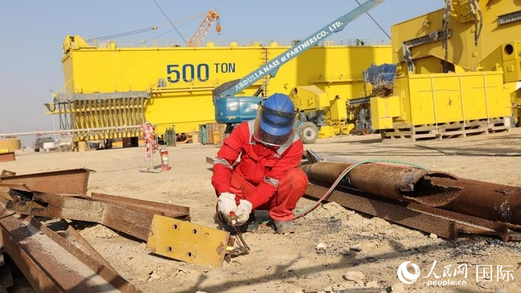 工人正在龍門吊吊裝現場切割金屬件。人民網記者管克江攝