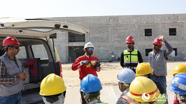 穆薩瓦爾(圖中紅衣人）現場演示工具操作規(guī)范。人民網記者 管克江攝