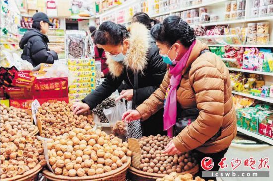 　　在長沙南門口菜市場附近的一家炒貨店內，市民正在選購年貨。　　長沙晚報全媒體記者 范宏歡 攝