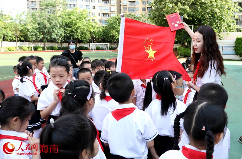 老師向少先隊(duì)員展示隊(duì)旗。人民網(wǎng) 符武平攝