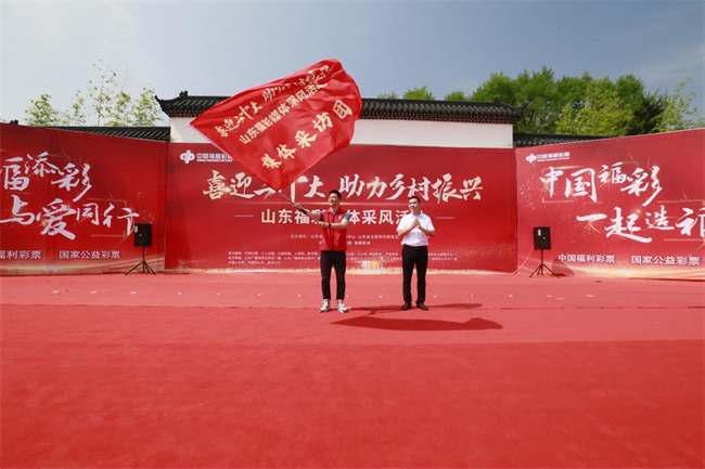 為媒體采風(fēng)團(tuán)授旗。 山東省福彩供圖