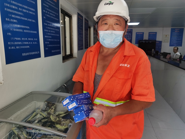 1環(huán)衛(wèi)工倪建宏小憩后，為還同事帶去冷飲。人民網記者王繼亮攝