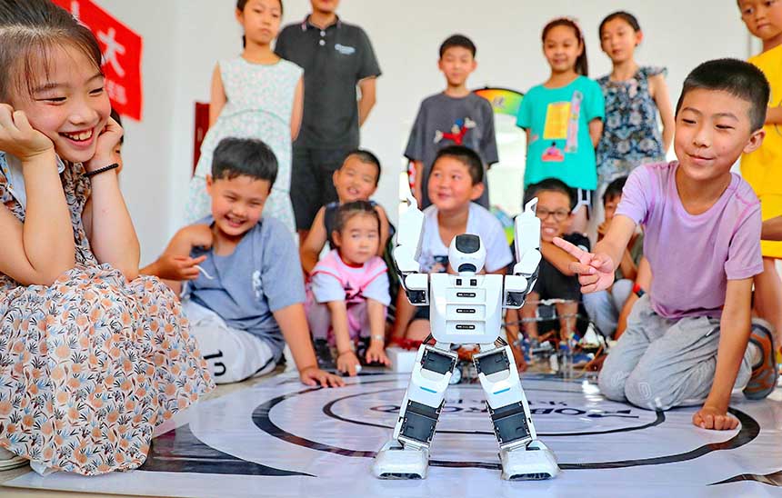 2022年7月19日，河北省秦皇島市海港區(qū)白塔嶺街道秦皇半島第二社區(qū)內(nèi)，小朋友正在觀看“機(jī)器人跳舞”。 曹建雄攝