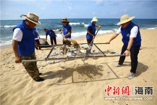環(huán)保志愿者用篩網(wǎng)“淘”出海灘上的垃圾。