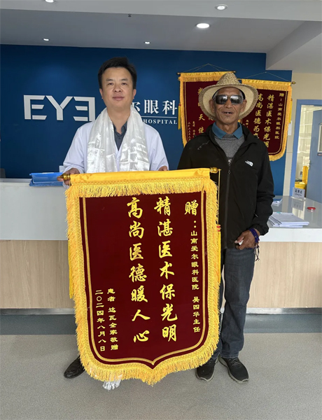 達瓦老人向吳四華（左）贈送錦旗。受訪者供圖