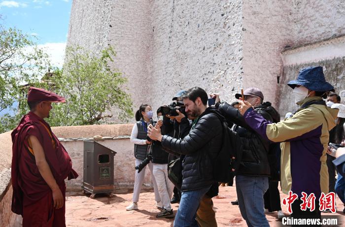 圖為中外媒體拍攝朝拜布達拉宮的僧人。　趙朗 攝