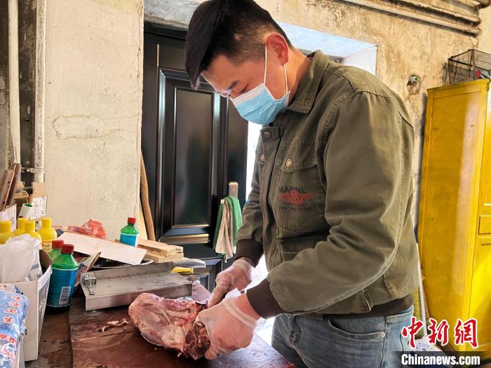 圖為雪豹“奶爸”史壽軍正在準(zhǔn)備投喂雪豹的食材?！●R銘言 攝