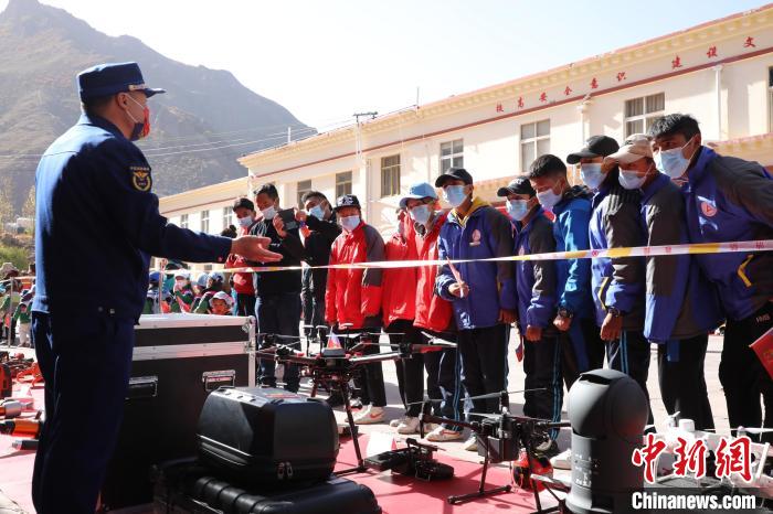 圖為消防指戰(zhàn)員為學(xué)生講解、演示先進(jìn)救援裝備?！≮w琳 攝